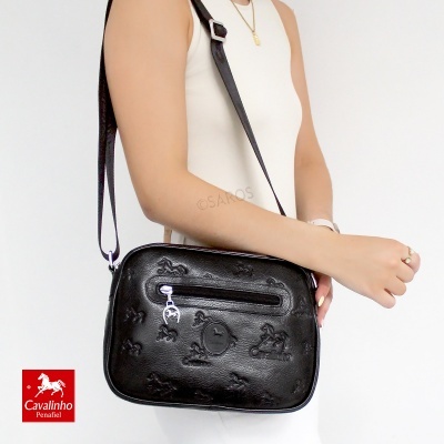 Mala de ombro preta com padrão de cavalos em relevo e fecho zipado frontal