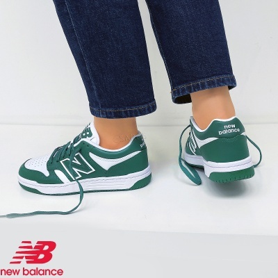 Ténis New Balance brancos e verdes usados com calças azuis