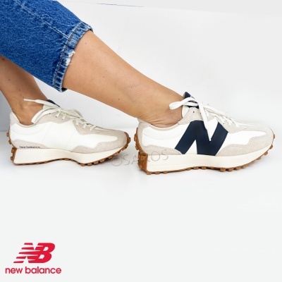 Ténis New Balance brancos e bege com sola castanha e logótipo preto usados com calças de ganga