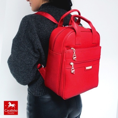 Mochila vermelha de material sintético com zíperes dourados e marca Cavalinho