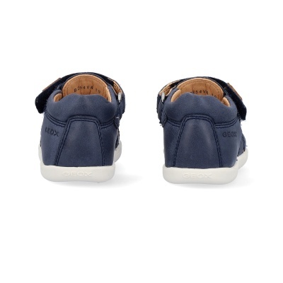 Sapatilhas azuis escuras para criança com sola branca e fecho de velcro, vista de trás.