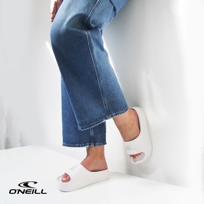 Chinelos brancos com sola grossa e abertos na frente, usados com jeans azul