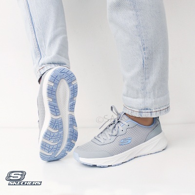 Ténis Skechers cinza claro com detalhes azuis e sola branca usados com jeans