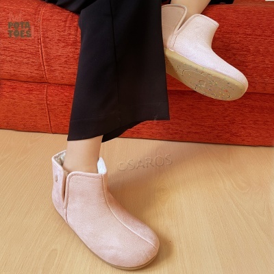 Botas cor de rosa claro com textura suave e sola antiderrapante num ambiente interior