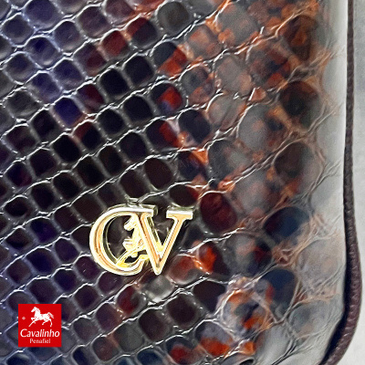 Pele com textura de escamas de cobra castanha e preta com símbolo dourado CV