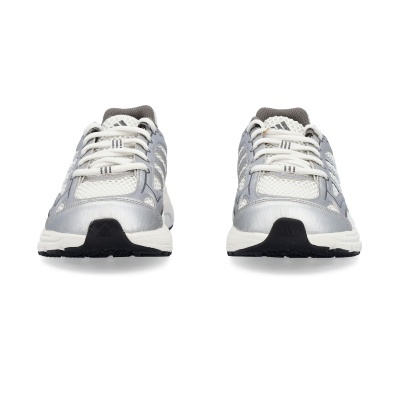 Par de ténis desportivos Adidas branco e cinza com sola preta em fundo branco