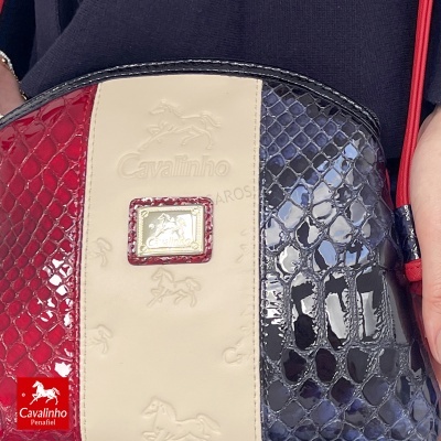 Mala Cavalinho em padrão pele de cobra vermelho e preto com faixa bege e placa dourada