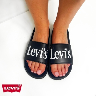 Chinelos pretos Levis com logo branco em uso