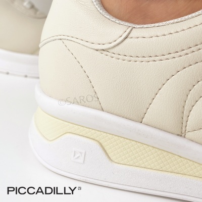 Sapato branco com sola branca e amarela e o texto PICCADILLY