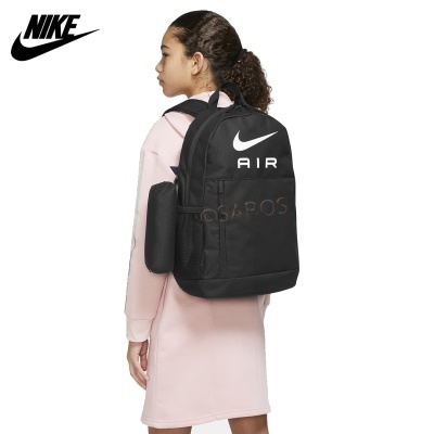 Mochila preta Nike AIR com logótipo branco usada por jovem com vestido rosa
