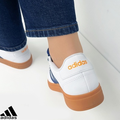 Ténis Adidas brancos com sola castanha e detalhes azuis, vista traseira