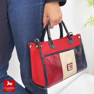 Mala de mão em tecido vermelho com detalhes em imitação de pele em tons vermelho, creme e azul escuro