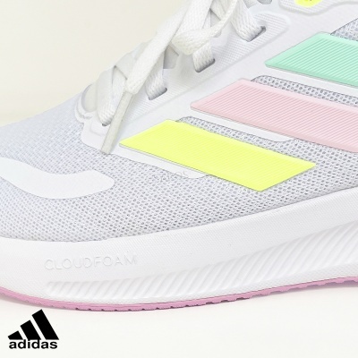 Ténis branco adidas com riscas coloridas pastel e sola rosa.