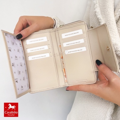 Carteira bege clara em couro sintético com fecho de botão dourado aberta com cartões dentro.