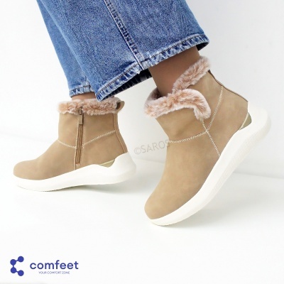 Botins bege com pêlo castanho claro e sola branca usados com jeans azuis