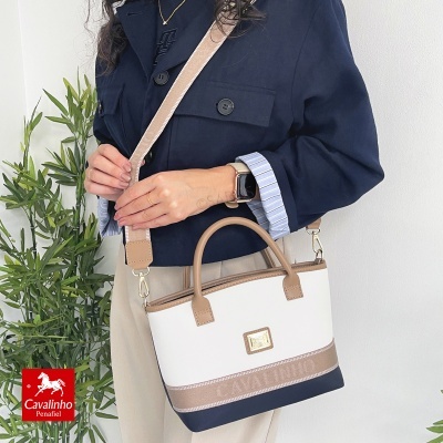 Mala Cavalinho branca, bege e azul escuro com alça ajustável e detalhes em couro.
