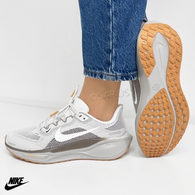 Ténis Nike brancos com detalhes cinza e sola laranja em fundo branco