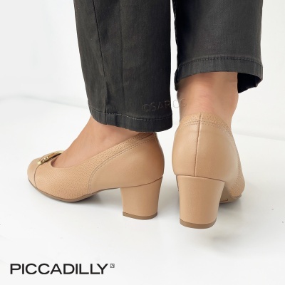 Sapatos de salto médio bege com textura granulada usados com calças pretas