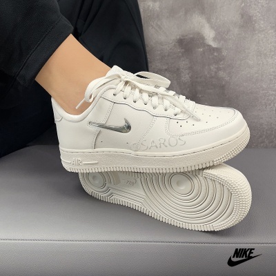 Ténis Nike Air Force 1 brancos com logótipo metálico prateado e sola texturada