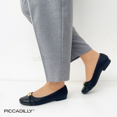 Sapatilhas pretas Piccadilly com padrão quadriculado e detalhe dourado, usadas com calças cinza.