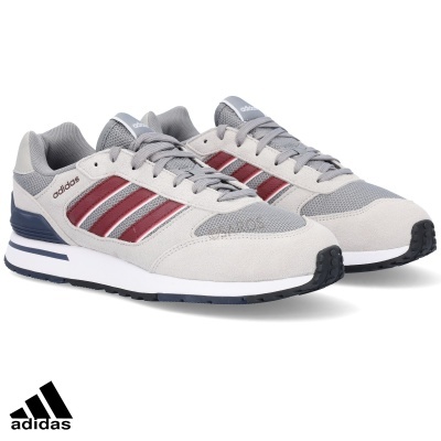 Sapatilhas Adidas cinzentas com riscas vermelhas sobre fundo branco