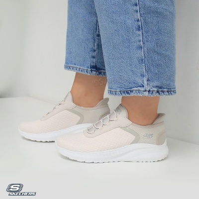 Ténis Skechers bege claro com sola branca e detalhes cinza usados com jeans azuis claros