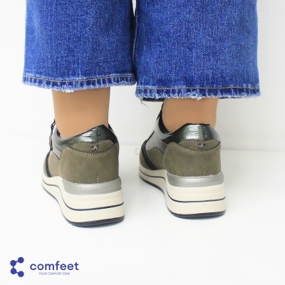 Ténis verdes com sola branca usados com calças de ganga azuis