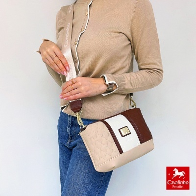 Mala de ombro bicolor bege e castanho com alça larga Cavalinho usada por pessoa