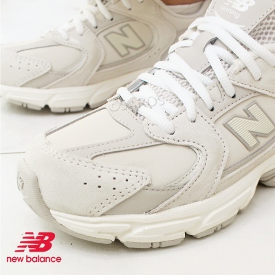 Ténis de corrida New Balance em bege com detalhes cinza e sola branca