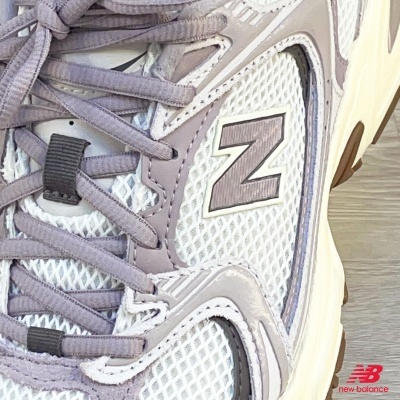 Sapatilha desportiva New Balance branca e cinzenta vista de perto
