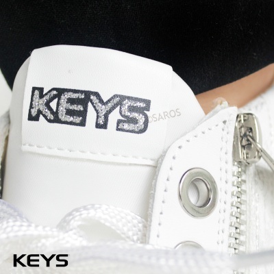 Ténis branco com etiqueta KEYs preta e brilhante e fecho metálico prateado
