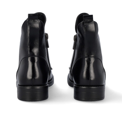 Botins pretos em couro com textura tipo escamas vistos de costas