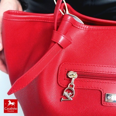 Mala de mão vermelha com pendente metálico de cavalo e logo Cavalinho Penafiel