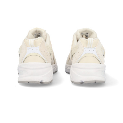 Par de ténis desportivos New Balance creme e branco visto de trás