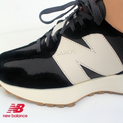 Sapatilha preta e branca New Balance com sola de borracha e logo vermelho