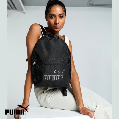 Mochila preta PUMA com logótipo branco, usada por mulher em fundo branco.