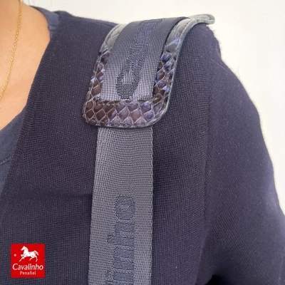 Alça de saco ou mochila cinzenta com detalhe em pele castanha e casaco azul escuro