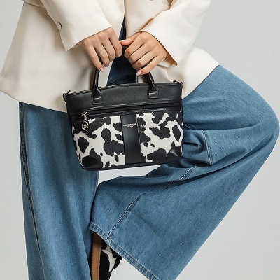 Mala pequena padrão pele de vaca com detalhes pretos