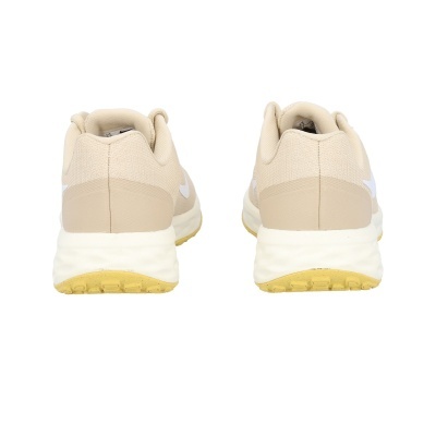 Ténis beges com sola branca e amarela vistos de trás