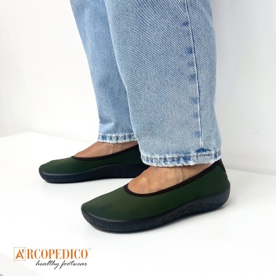 Sapatos femininos verdes com sola preta usados com calças de ganga