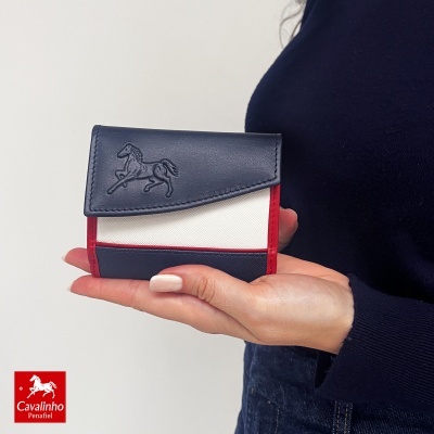 Carteira Cavalinho azul, branco e vermelho com cavalo em relevo segurada por mão de mulher