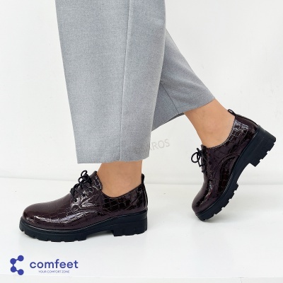 Sapatos oxford castanhos escuros com sola preta e textura tipo crocodilo