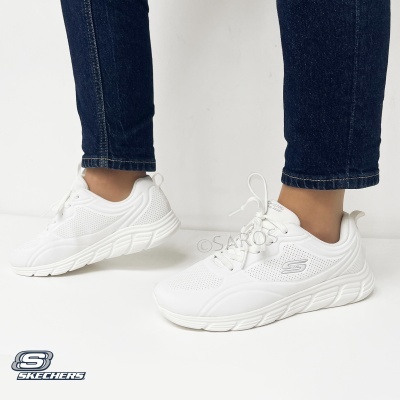 Ténis brancos Skechers com sola grossa e perfurações usados com calças de ganga azul