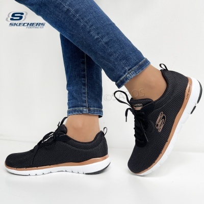 Ténis Skechers pretos com sola branca e detalhe castanho usados com calças de ganga azul