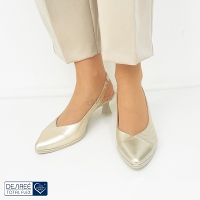 Sapatos de salto médio dourados com calças bege claras e fundo branco