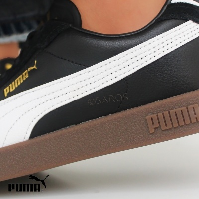 Tênis Puma preto com faixa branca e sola castanha