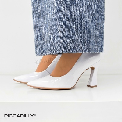 Sapatos de salto alto brancos verniz com sola bege usados com calças de ganga