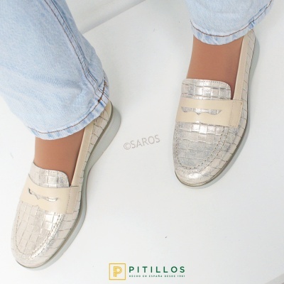Sapatos tipo mocassim prateados e bege com padrão quadriculado usados com calças de ganga