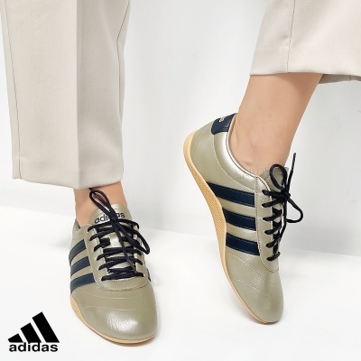 Sapatilhas adidas cinza com riscas pretas e sola castanha