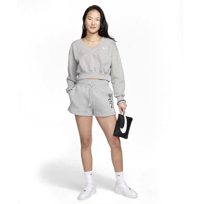 Mulher a usar conjunto desportivo cinzento da Nike e clutch preta com símbolo Nike branco.